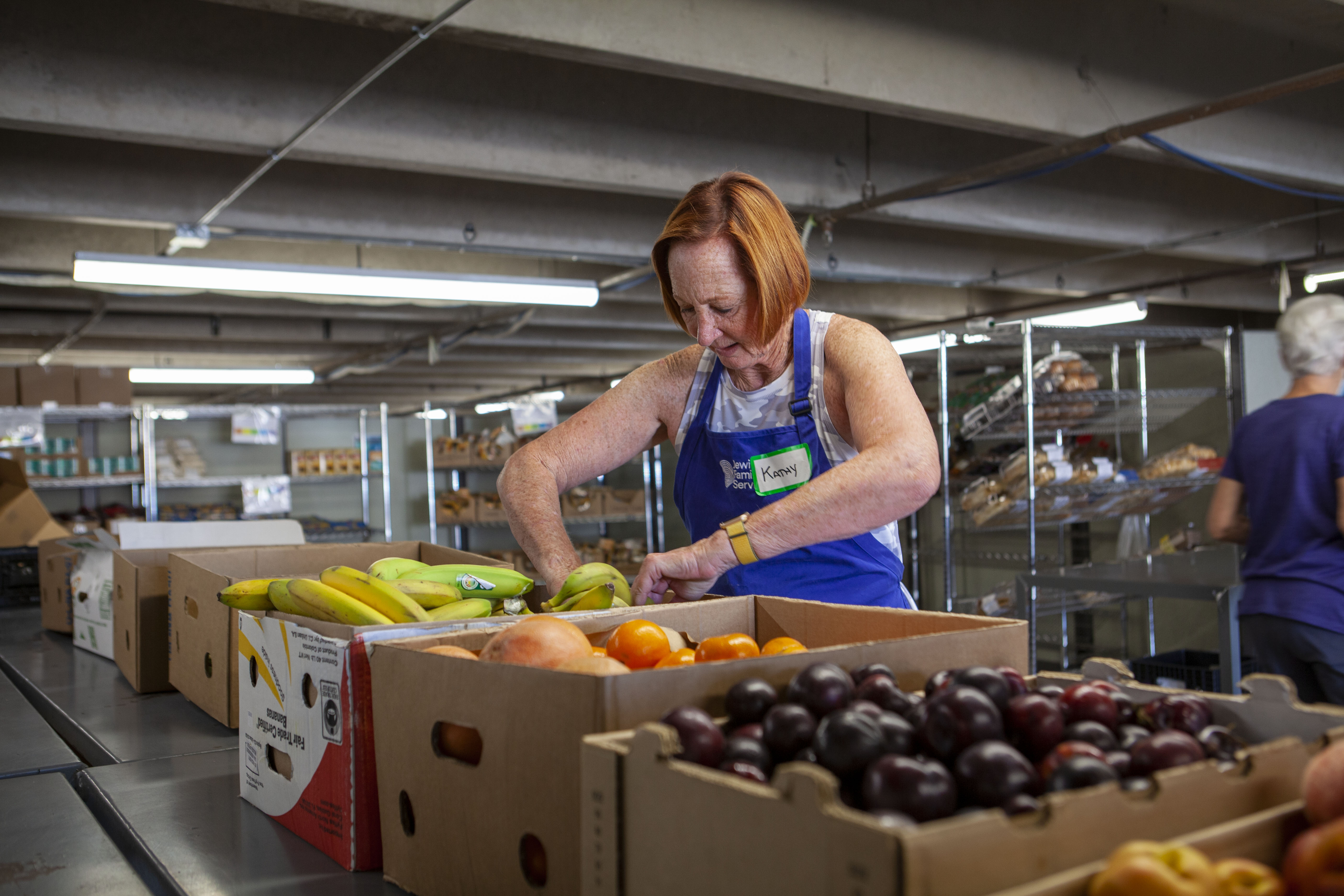 Volunteer Kathy Sabine prepares boxes of food at the Harry and Jeanette Weinberg Food Pantry in Denver. 