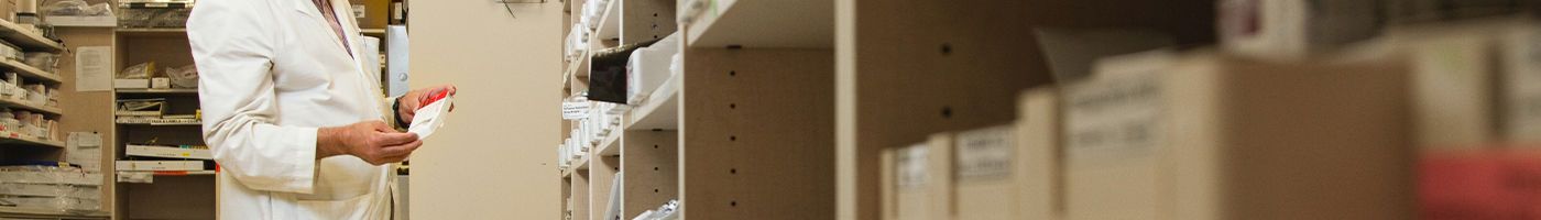 Pharmacist pulling stock from shelves