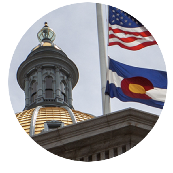 The American and Colorado flags fly next to the Colorado Capitol dome