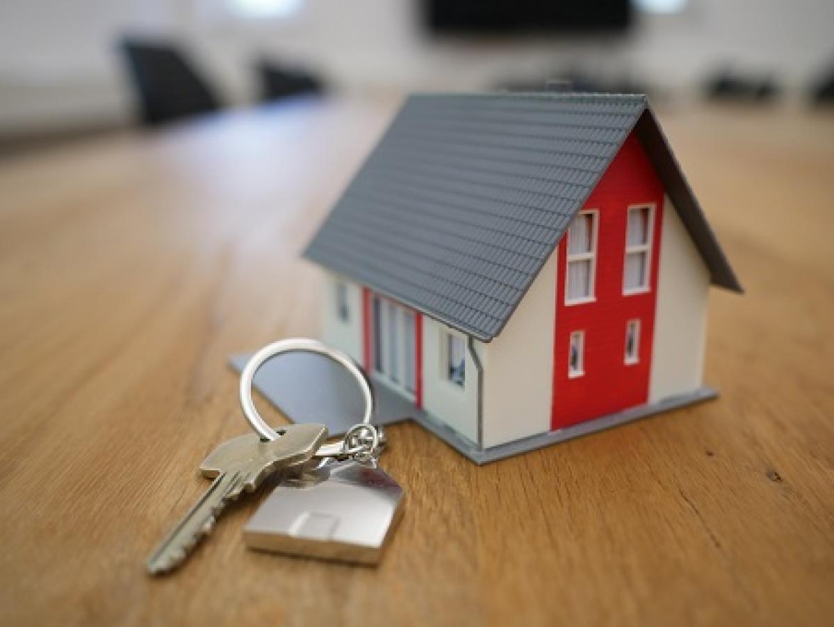 Toy house next to a keyring on a table.