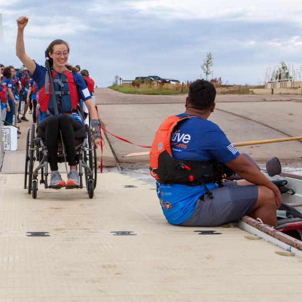 Alison Rehfus greets coach Gilbert Vasquez on her way to the Team Blue dragon boat.